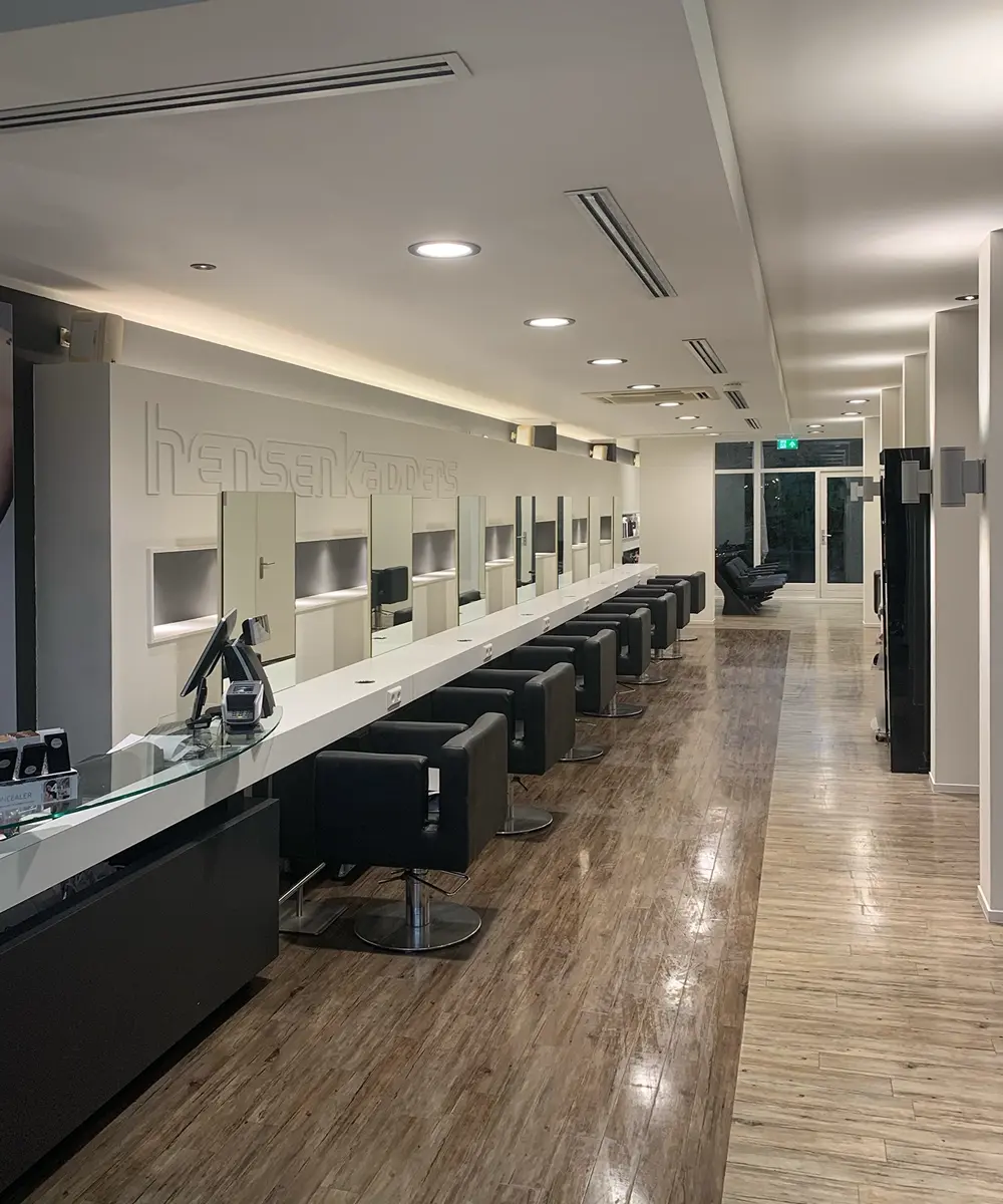 Het interieur van de salon met een lange rij kappersstoelen en spiegels